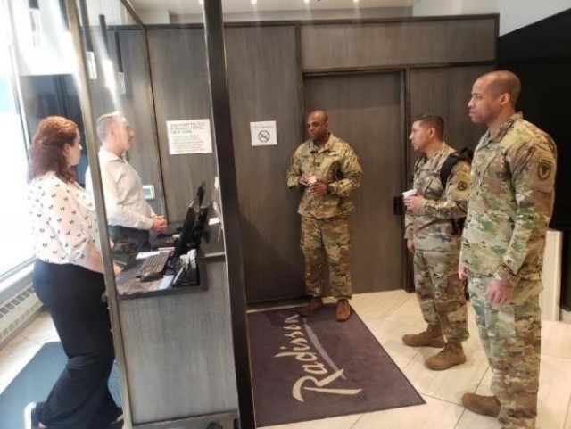 From left, Lt. Col. Jason Miles, Master Sgt. Cirildo Guerrero Jr., and Maj. Jermaine Pruitt answer inquiries from the staff at a hotel in New York City. Miles and Pruitt are deployed to New York City to provide contracting support to Soldiers from...