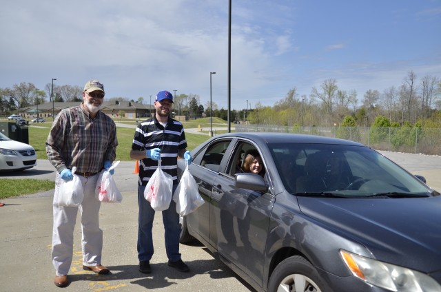 Barsanti Elementary School Principal Hugh McKinnon and Assistant Principal Robert Battey help distribute grab-and-go breakfast and lunch meals for children 18 and younger at Barsanti, Fort Campbell.