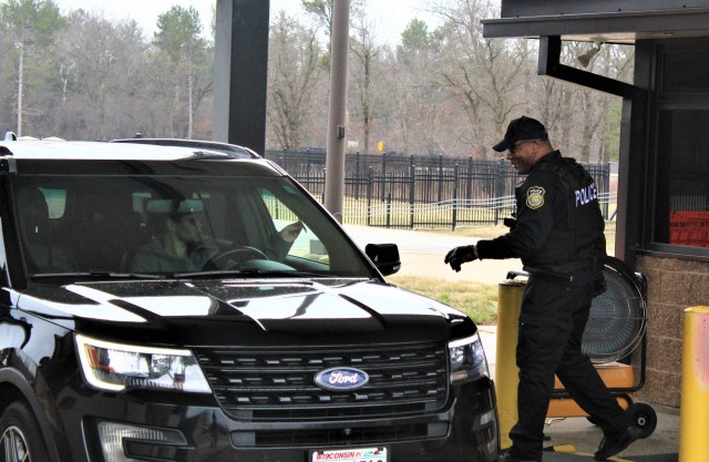Officer Emanuel Brown with the Directorate of Emergency Services Police Department reviews a motorist’s ID and asks screening questions April 3, 2020, at the Main Gate entry control point at Fort McCoy, Wis. Fort McCoy police have limited entry to the installation since the start of the installation’s response to the COVID-19 pandemic in March 2020. (U.S. Army Photo by Scott T. Sturkol, Public Affairs Office, Fort McCoy, Wis.)