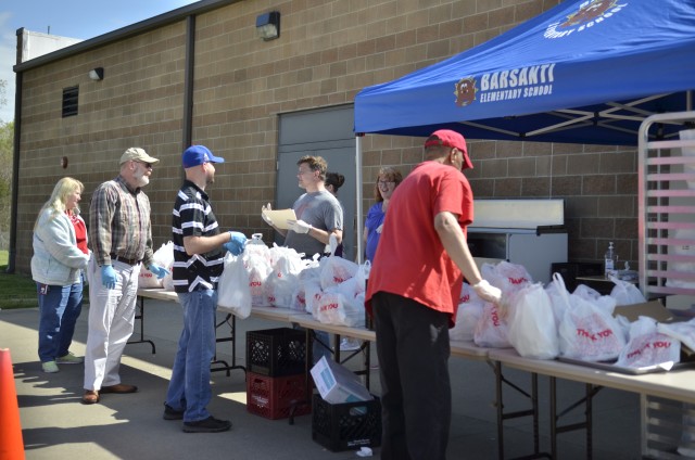 A team of workers and volunteers help hand out grab-and-go breakfast and lunch meals provided by the Fort Campbell Child Nutrition Program for children 18 and younger at Barsanti Elementary School, Fort Campbell.