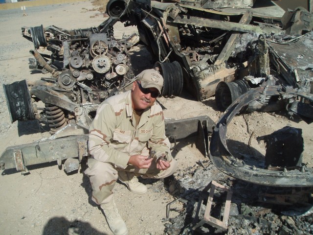 Quality Assurance Specialist (Ammunition Surveillance) Rick Vice, assists Explosive Ordnance Disposal technicians screen battle damaged vehicles for unexploded ordnance, prior to bringing the equipment on to base in Kandahar, Afhghanistan.