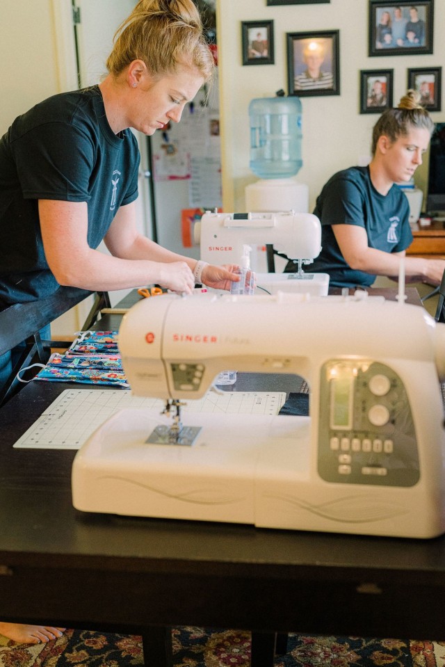 Schuyler Crowder, 1st Battalion F.I.R.S.T. Spouse Mentorship Group events coordinator, and Kati Poston, 1st Battalion F.I.R.S.T. Spouse Mentorship Group Chair, prep their workstations to begin assembling masks to be packaged and sent out in...