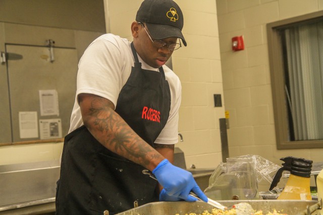 Spc. Mely Rogers, culinary specialist, G Company, 1st Battalion, 327th Infantry Regiment, 1st Brigade Combat Team “Bastogne”, 101st Airborne Division preparing lunch April 2 in the Snipes Dining Facility on Fort Campbell, Kentucky. The Snipes Dining Facility is remaining open seven days a week to ensure Bastogne Soldiers safely receive a healthy meal to sustain their physical and mental readiness during their response to COVID-19. U.S. Army photo by Maj. Vonnie Wright.