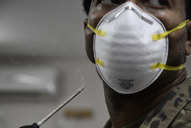 An Airman receives a cloud of smoke to test the ventilation of his N95 mask issue at Ahmed Al Jaber Air Base, Kuwait March 13, 2020. Airmen serving in specific mission sets with potential exposure to the COVID-19 virus are provided with an N95 mask.