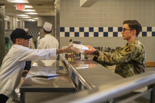 Pvt. Baltazar Mancilla, left, J Company, 1st Battalion, 506th Infantry Regiment, 1st Brigade Combat Team “Bastogne”, 101st Airborne Division, serves a lunch carryout tray to Spc. Jacob Urban, right, B Company, 2nd Battalion, 327th Infantry Regiment on April 2 in Snipes Dining Facility on Fort Campbell, Kentucky. The Snipes Dining Facility serves meals that Soldiers may pick up for carryout only everyday as a precautionary measure in response to COVID 19. U.S. Army photo by Maj. Vonnie Wright.