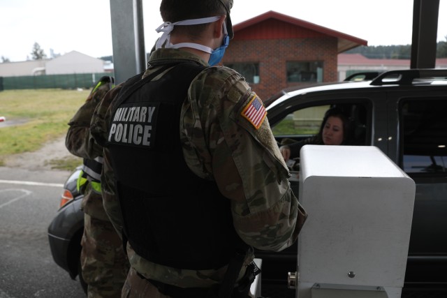 JOINT BASE LEWIS-MCCHORD, Wash. – Spc. Cameron S. Gilber, military police, 66th Military Police Company, 504th Military Police Battalion, 42nd Military Police Brigade, checks IDs at DuPont Gate, April 7, 2020. To assist with the shortage of...