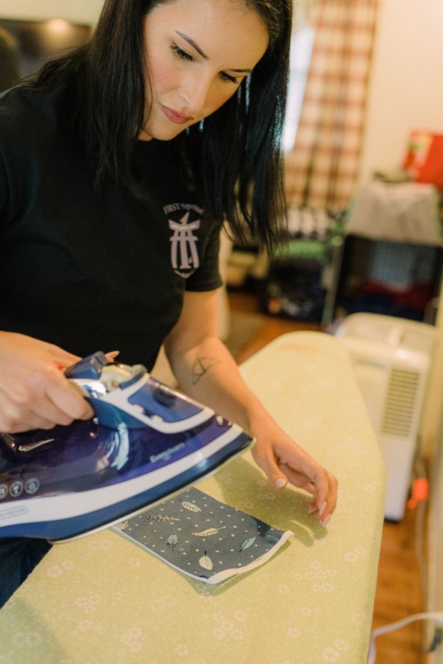 Amanda Patterson, 1st Battalion F.I.R.S.T. Spouse Mentorship Group events coordinator, presses fabric squares to be used for masks in Okinawa, Japan, Mar. 29, 2020. The spouses have contributed masks to the Emergency Response Center and the emergency department of the U.S. Naval Hospital Okinawa for medical personnel to safely render the proper care during the COVID-19 pandemic. (Courtesy Photo by Lisa Song)