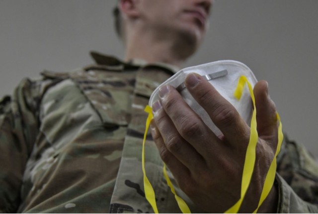 An Airman assigned to 407th Expeditionary Logistics Readiness Flight, adjusts the straps to his N95 mask to begin a fit test at Ahmed Al Jaber Air Base, Kuwait, March 13, 2020. Airmen are provided a N95 mask that is serving in a specific mission...