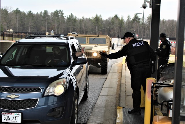 Officers Mark Johnson and Emanuel Brown with the Directorate of Emergency Services Police Department review a motorist IDs and ask screening questions April 3, 2020, at the Main Gate entry control point at Fort McCoy, Wis. Fort McCoy police have limited entry to the installation since the start of the installation’s response to the COVID-19 pandemic in March 2020. (U.S. Army Photo by Scott T. Sturkol, Public Affairs Office, Fort McCoy, Wis.)