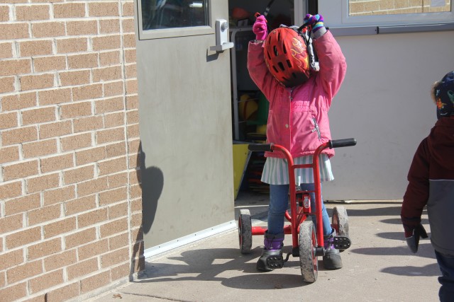 A student at the Child Development Center (CDC) puts on a bike helmet March 17, 2020, at Fort McCoy, Wis. The CDC is Department of Defense certified and nationally accredited. (U.S. Army photo by Aimee Malone, Public Affairs Office, Fort McCoy, Wis.)