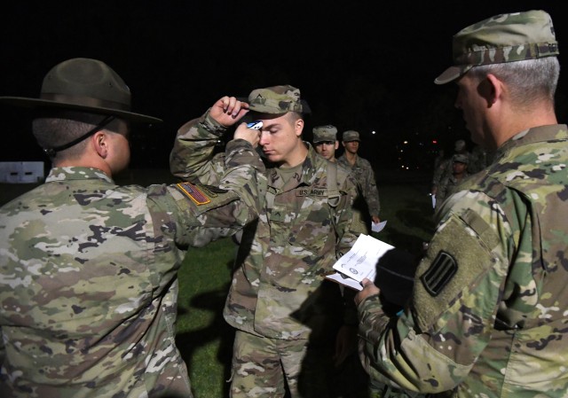 Pvt. Thomas Essman, a basic combat training graduate, has his temperature taken at Fort Jackson, S.C., March 31, 2020, before he boards a bus that will take him to his advanced individual training in Fort Lee, Va.