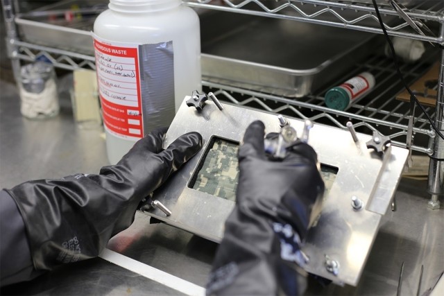 Chris Steinbach places agent onto material as part of initial testing to demonstrate that the test cell does not leak around the edges of a zipper