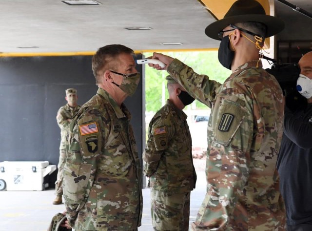 Army Chief of Staff Gen. James C. McConville, left, gets his temperature taken at Fort Jackson, S.C., April 15, 2020. McConville visited the training post to get a closer look at how it was adapting to new COVID-19 safety measures.