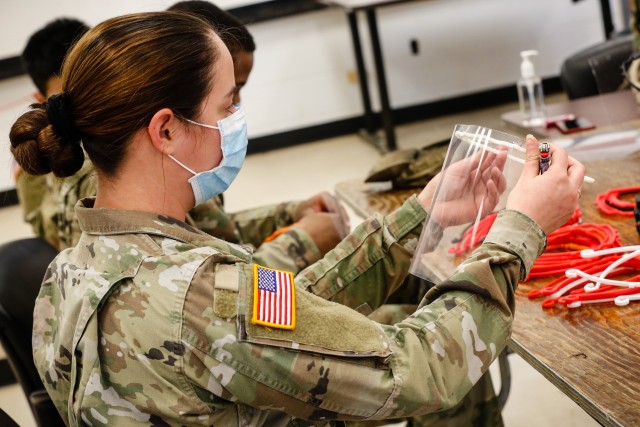 Pfc. Dainerys Caballero, a signal support systems specialist with the 18th Field Artillery Brigade, finishes assembling a face shield at Fort Bragg, N.C., on April 15, during Operation Dragon Mask. Units from across Fort Bragg were repurposed to...