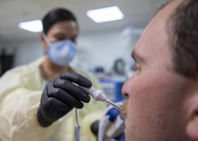 U.S. Navy Lt. Gail Evangelista, nurse, assigned to Naval Hospital Rota, Spain, takes a patient’s temperature at the Michaud Expeditionary Medical Facility (EMF) at Camp Lemonnier, Djibouti, April 16, 2020. Evangelista is part of a four-member team sent by Naval Forces Africa to augment critical positions within the EMF during the COVID-19 pandemic, enabling existing EMF staff to fulfill their primary mission of treating trauma patients. (U.S. Air Force photo by Senior Airman Dylan Murakami)