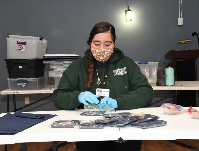 Lorena Currea, a volunteer at the Fort Drum USO Center, helps assemble face mask kits April 16 that will be distributed to community members. (Photo by Mike Strasser, Fort Drum Garrison Public Affairs)