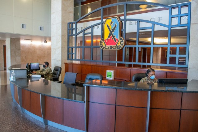 FORT BENNING, Ga. – Soldiers on reception desk duty inside the headquarters of Fort Benning's Maneuver Center of Excellence April 15, wear face masks under a recent Department of Defense directive, as a precaution against the spread of COVID-19.