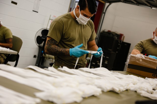 Sgt. Allen Villaplando, a parachute rigger with the 647th Quarter Master Company, 3rd Expeditionary Sustainment Command, prepares fabric to be sewn into protective masks at Fort Bragg, N.C., on April 15, as part of Operation Dragon Mask. Units...