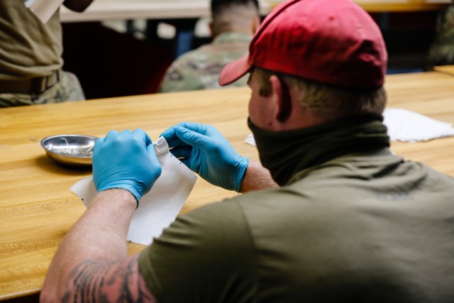 A U.S. Army parachute riggers with the 647th Quarter Master Company, 3rd Expeditionary Sustainment Command, prepare fabric to be sewn into protective masks at Fort Bragg, N.C., on April 15, as part of Operation Dragon Mask. Units from across Fort Bragg were repurposed to create face masks, face shields, and other personal protective equipment to be distributed as part of the COVID-19 response. (U.S. Army Photo by Spc. Hubert D. Delany III)