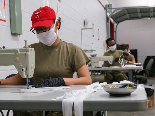 Pfc. Rosi Veldez, left, a parachute rigger with the 647th Quarter Master Company, 3rd Expeditionary Sustainment Command, sews surgical masks at Fort Bragg, N.C., on April 15, as part of Operation Dragon Mask. Units from across Fort Bragg were repurposed to create face masks, face shields, and other personal protective equipment to be distributed as part of the COVID-19 response. (U.S. Army Photo by Sgt. Liem Huynh)