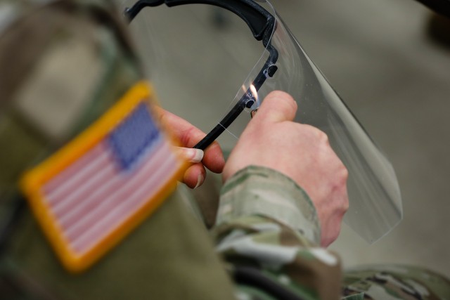 A U.S. Army Soldier with the 18th Field Artillery Brigade, assembles a face shield by melting the plastic guard to a frame at Fort Bragg, N.C., on April 15, during Operation Dragon Mask. Units from across Fort Bragg were repurposed to create face...