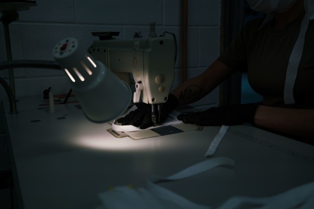 A U.S. Army parachute rigger with the 647th Quarter Master Company, 3rd Expeditionary Sustainment Command, sews a surgical mask at Fort Bragg, N.C., on April 15, during Operation Dragon Mask. Units from across Fort Bragg were repurposed to create...