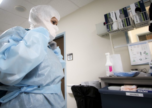 Dorothy Hall, a critical care nurse at Landstuhl Regional Medical Center, dons personnel protective equipment during COVID-19 operations at LRMC’s Intensive Care Unit, April 1. Health care personnel across LRMC are on the front lines for...