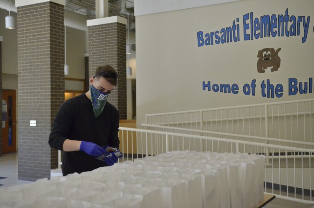 Specialist Matthew Dove, vice president of the Fort Campbell BOSS program, helps package free grab-and-go breakfast and lunch meals for children ages 18 and younger, April 16, at Barsanti Elementary School. The free food distribution is part of the Fort Campbell Child Nutrition Program. (Emily LaForme, Fort Campbell Courier)