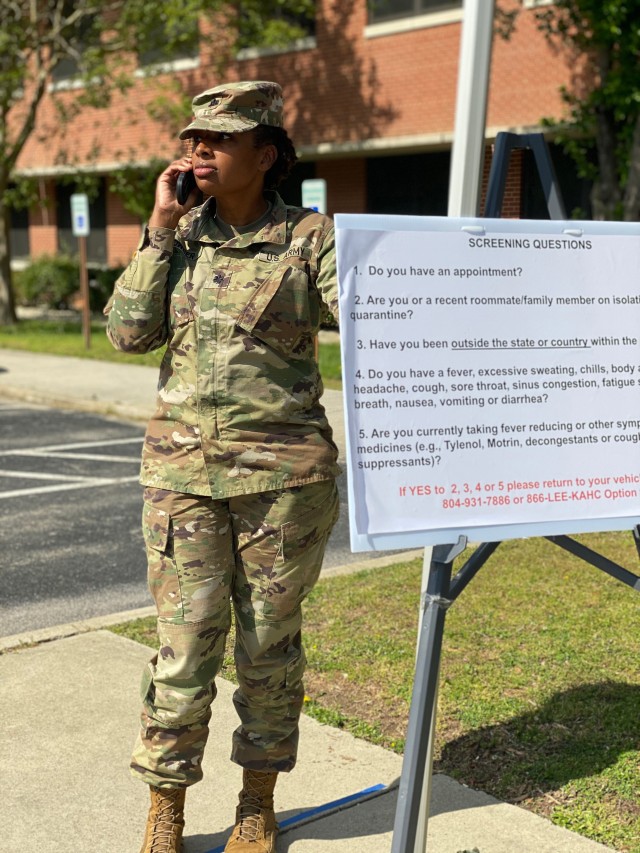 Deputy to the Commander for Nursing, Lt. Col Tameka D. Bowser, answers a community member’s questions about COVID-19 testing while observing the screening activities Tuesday at the entrance of Kenner Army Health Clinic. (Photo by CPT Kathy...