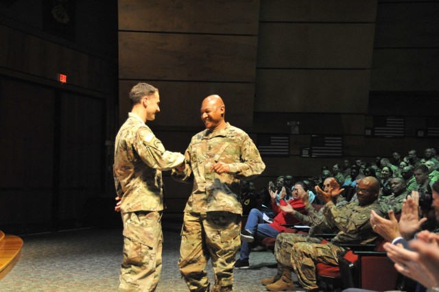 Picture previously taken by David Crozier- During the quarterly distinguished service and recognition ceremony at the NCO Leadership Center of Excellence Master Sgt. David Zeek (left) is presented a coin by Command Sgt. Maj. Jimmy Sellers (right) for receiving the highest Army Combat Fitness Test score at the NCOLCoE to date, March 6.