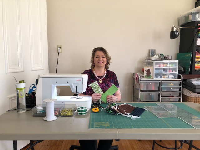 Cosy Sims sits beside the sewing machine she use to produce face masks for donation to hospitals and first responders. Along with another First Army spouse, Debbie Rogers, the two have produced more than 900 masks.  