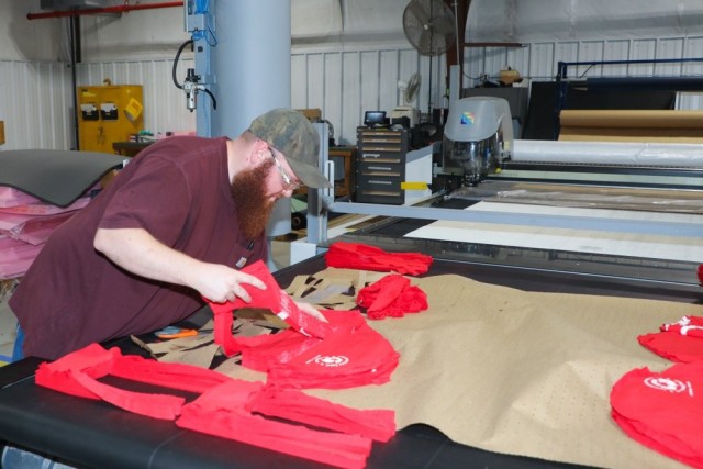 Logan Robinson, Letterkenny Army Depot upholstery shop employee, cuts fabric for the production of cloth masks at Letterkenny Army Depot in Chambersburg, Pa. The masks are being produced as part of LEAD's efforts to mitigate the spread of the...