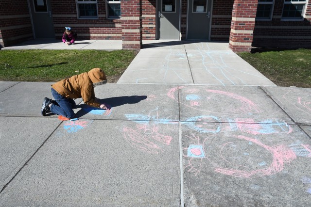 To celebrate Month of the Military Child, children at the Fort Drum School Age Center and Chapel Child Development Center participated in a sidewalk chalk art project April 20. (Photo by Mike Strasser, Fort Drum Garrison Public Affairs)