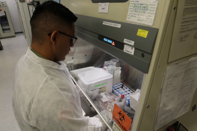 SGT Michael Estrada, medical lab technician, preps samples in the hospital lab to be transported to BSL3. (U.S. Army Courtesy photo by: Amabilia Payen, WBAMC Public Affairs.)