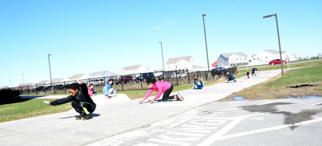 To celebrate Month of the Military Child, children at the Fort Drum School Age Center and Chapel Child Development Center participated in a sidewalk chalk art project April 20. (Photo by Mike Strasser, Fort Drum Garrison Public Affairs)