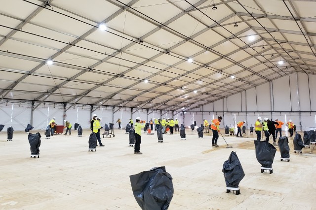 Workers prepare the flooring inside a climate-controlled tent under construction that will serve as an alternate care facility at the State University of New York at Stony Brook, New York. 