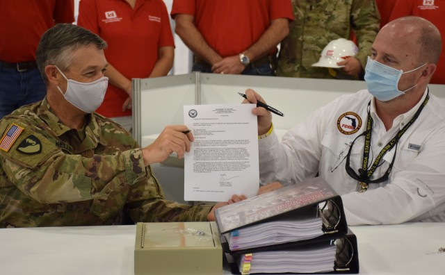 Col. Andrew Kelly, commander of the Jacksonville District of the U.S. Army Corps of Engineers, hands a letter certifying the completion of the Alternate Care Facility the district built in the Miami Convention Center to Kevin Guthrie, Deputy...