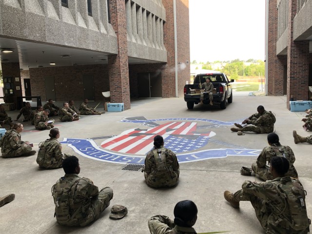 Chaplain (Capt.) Deborah Frick preaches to her unit out of the back of a
pick up truck. (Courtesy Photo)