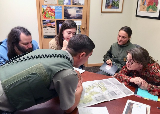 Looking over a map of Zion National Park (clockwise from left) park ranger Tim Knauss, Sacramento District's Darrin Rummel and Corrie Stetzel, Zion Park Ranger Annette Werderich, and Sacramento District's Lori Schultz, work together to determine strategic locations for placement of stream and rain gauges.