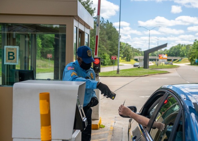 FORT BENNING, Ga. – At Fort Benning's main gate April 24, A security guard does an electronic check of an identification card at Fort Benning's main gate April 24. To minimize the spread of COVID-19, officials in March banned most visits,...