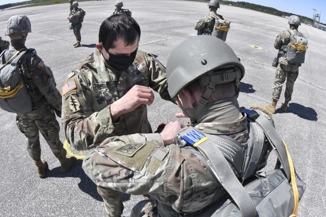 Staff Sgt. Daniel Pedregon, rigger instructor, Aerial Delivery and Field Services Department, adjusts the equipment of troops prior to an airborne operation April 22 at Blackstone Army Airfield at Fort Pickett. The operation was the first since the coronavirus crisis grounded Quartermaster School airborne operations in early March.