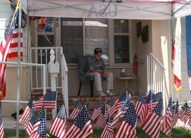 Retired U.S. Army Lt. Col. Sam Sachs watches from his front porch as a parade drives by his home during a celebration in his honor in Lakewood, Calif., on April 26, 2020. The celebration and parade honored the World War II veteran’s 105th birthday. Sachs was an officer with the 325th Glider Infantry Regiment, 82nd Airborne Division, and landed his glider on the beaches of Normandy during D-Day. 