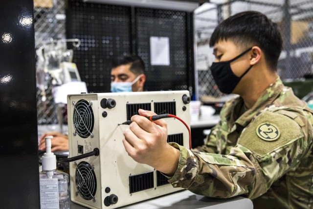 Army Sgt. Jung Huh, right, and Spc. Edwin Nicolas, both biomedical equipment specialists with the 807th Medical Command, test a Fiber Optic Endoscope Instrument Light while conducting preventive maintenance and repairs on medical equipment at the Medical Equipment Concentration Site for the 88th Readiness Division in Ogden, Utah, April 17, 2020. Soldiers and civilians working and volunteering at MECS 88 maintain and repair medical equipment in preparation to deploy it in support of Army Reserve medical units responding to the COVID-19 pandemic. (U.S. Army Reserve photo by Sgt. Jeremiah Woods)