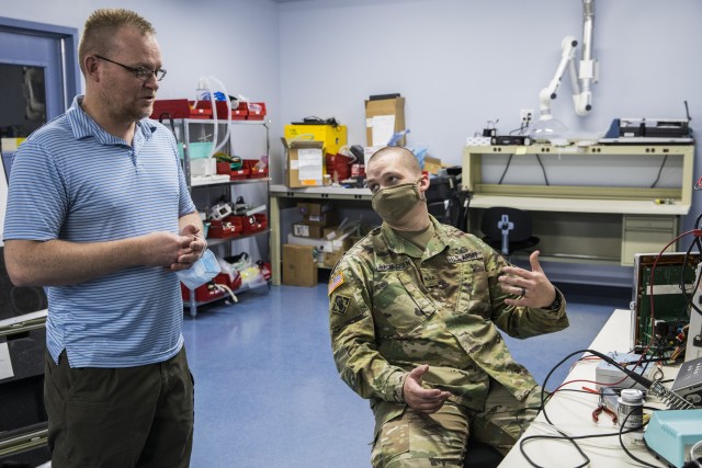 Army Warrant Officer Candidate Korey Rasmussen, training to be a health services maintenance technician with the 971st Medical Logistics Company, 807th Medical Command, talks with Kelly Chartier, project manager at the Medical Equipment Concentration Site for the 88th Readiness Division while servicing an Impact 754 Ventilator while conducting preventive maintenance and repairs on medical equipment in Ogden, Utah, April 17, 2020. Soldiers and civilians working and volunteering at MECS 88 maintain and repair medical equipment in preparation to deploy it in support of Army Reserve medical units responding to the COVID-19 pandemic. (U.S. Army Reserve photo by Sgt. Jeremiah Woods)