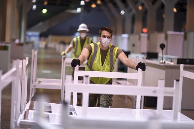 U.S. Air Force Senior Airman Nathan Oller, from the 182d Airlift Wing, based in Peoria, Ill., readies hospital beds in a wing dedicated to elderly patients ahead of a scheduled dry run of medical students posing as patients at McCormick Place...