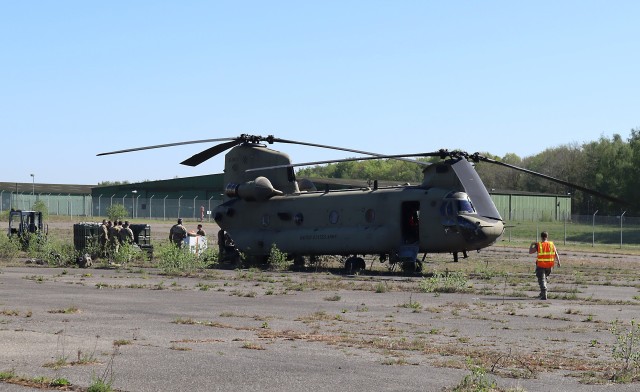 Team members at the U.S. Army Medical Materiel Center-Europe assist in unloading a Chinook helicopter carrying equipment for the 3rd Combat Aviation Brigade, 3rd Infantry Division on April 22. The 3rd CAB received dozens of mission-essential equipment replacements, including ventilators and defibrillators during the stopover. (U.S. Army photo by Troy Bentz)