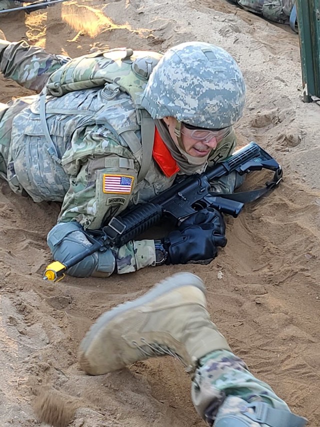 Sgt. Michael Murray, a trainee assigned to 2nd Battalion, 39th Infantry Regiment, Fort Jackson, South Carolina, low crawls under a razor wire obstacle during the final training event - The Forge. Murray began his military career in 1992 and has...