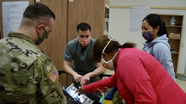 A U.S. Soldier and Department of Defense civilians learn how to operate a ventilator in Rose Barracks, Germany, April 21, 2020. The ventilator is an essential item for treating some of the most severe symptoms of the coronavirus. (U.S. Army photo by Maj. John Ambelang)