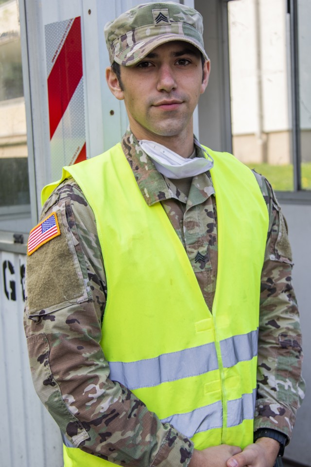 U.S. Army Sgt. Mark McAlvain, an infantryman with the Comanche Troop, 1st Squadron, 2d Cavalry Regiment, poses for a photo at the Crestview checkpoint in U.S. Army Garrison Wiesbaden, Germany, April 19, 2020,.  McAlvain, a Reno, Nevada, native, is currently assisting the garrison by conducting medical screenings for COVID-19. (U.S. Army photo by Staff Sgt. Ryan Rayno)