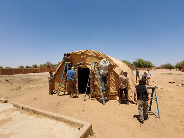 The U.S. Army 443rd Civil Affairs Battalion, Civil Affairs Team 219 and U.S. Air Force civil engineers assigned to Nigerien Air Base 201 in Agadez, Niger, build a tent they donated and delivered to the Agadez Regional Public Hospital April 6, 2020. CAT 219 reached out to local medical facilities to ascertain what supplies and equipment were needed to assist Nigerien health care providers in protecting themselves and enhancing capabilities to prevent infections and provide effective health care for potential COVID-19 patients. The hospital director requested a tent to be used as a quarantine space in the case of a potential coronavirus outbreak (U.S. Army photo)